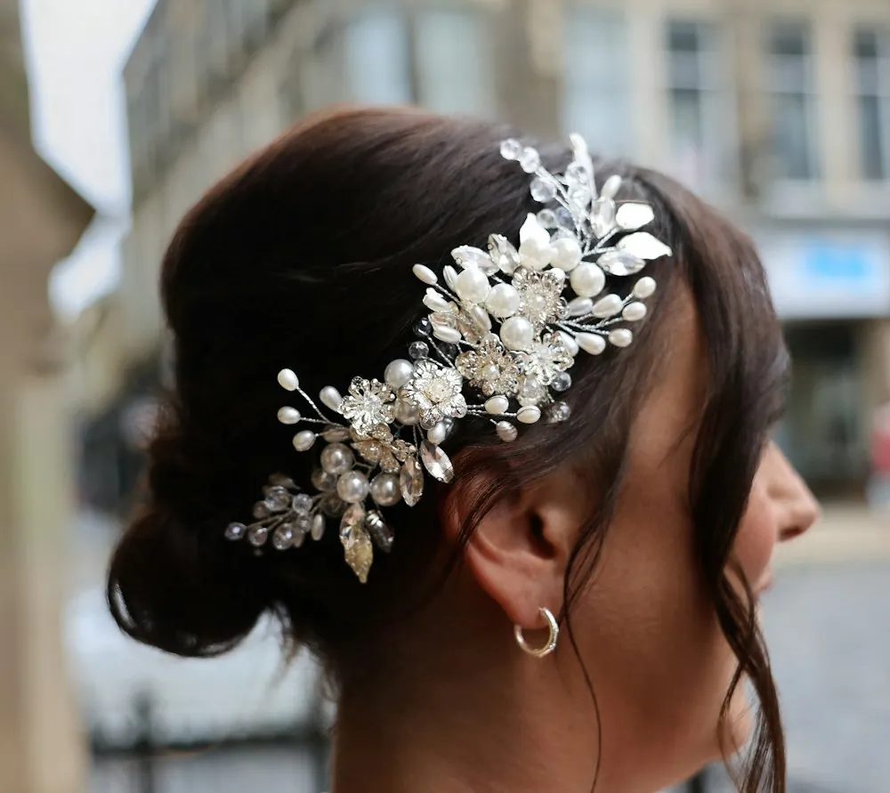A low chignon decorated with a pearl and crystal hair comb